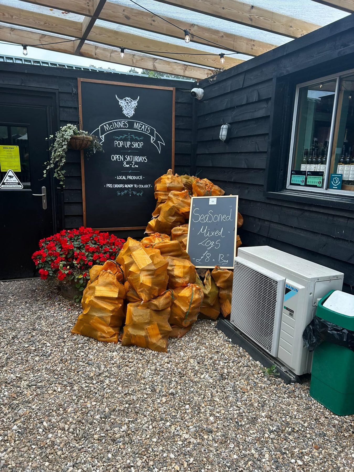 The farm shop door with bags of logs outside